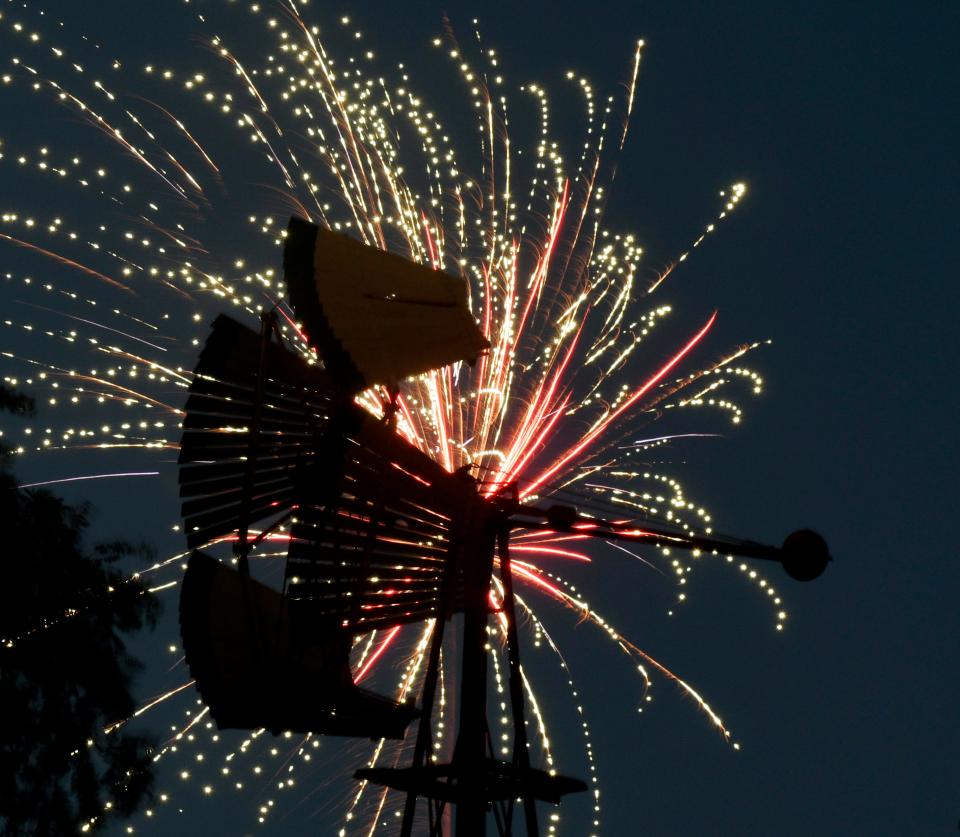 Fireworks explode behind a windmill during the “Fireworks Extravaganza,” Tuesday, July 4, 2023, at Mackenzie Park.