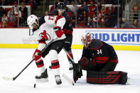 New Jersey Devils' Wayne Simmonds (17) tries to control the puck in front of Carolina Hurricanes goaltender Petr Mrazek (34), of the Czech Republic, during the third period of an NHL hockey game in Raleigh, N.C., Friday, Feb. 14, 2020. (AP Photo/Karl B DeBlaker)