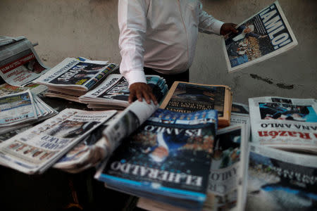 A man arranges newspapers after the election of Andres Manuel Lopez Obrador as new Mexican President in Mexico City, Mexico, July 2, 2018. REUTERS/Edgard Garrido