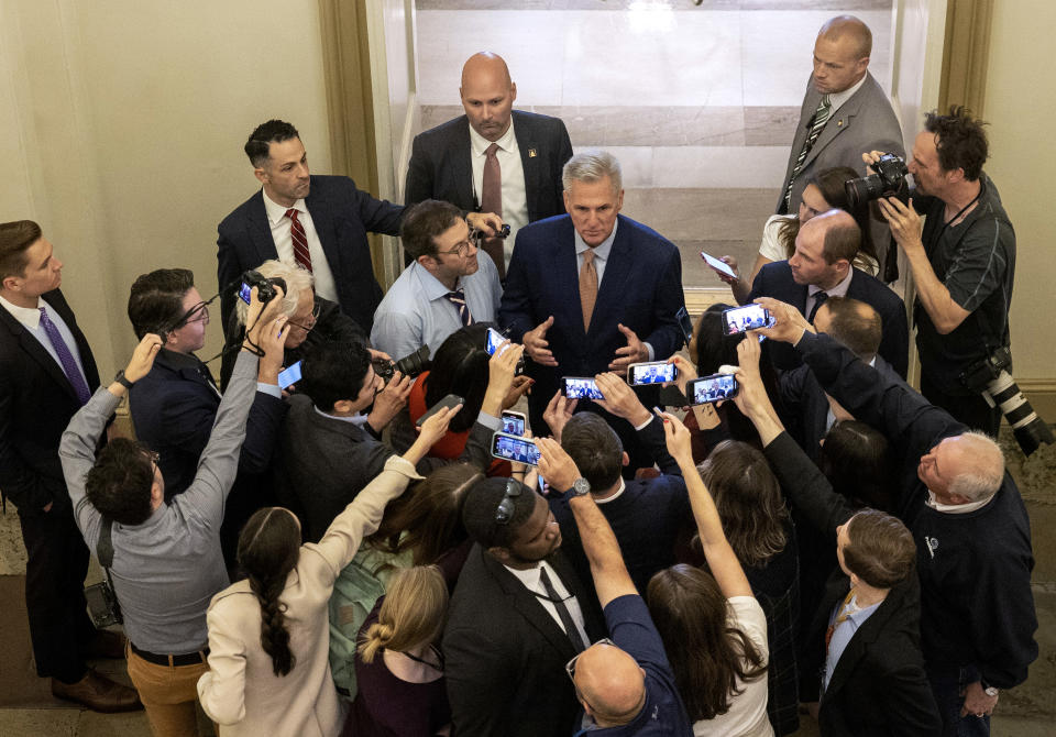 Kevin McCarthy surrounded by reporters holding out cellphones.