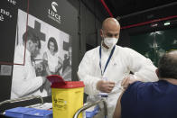 A man receives a dose of the Pfizer COVID-19 vaccine, at a vaccination center set at Rome's Cinecitta' film studios, Tuesday, April 20, 2021. (AP Photo/Andrew Medichini)