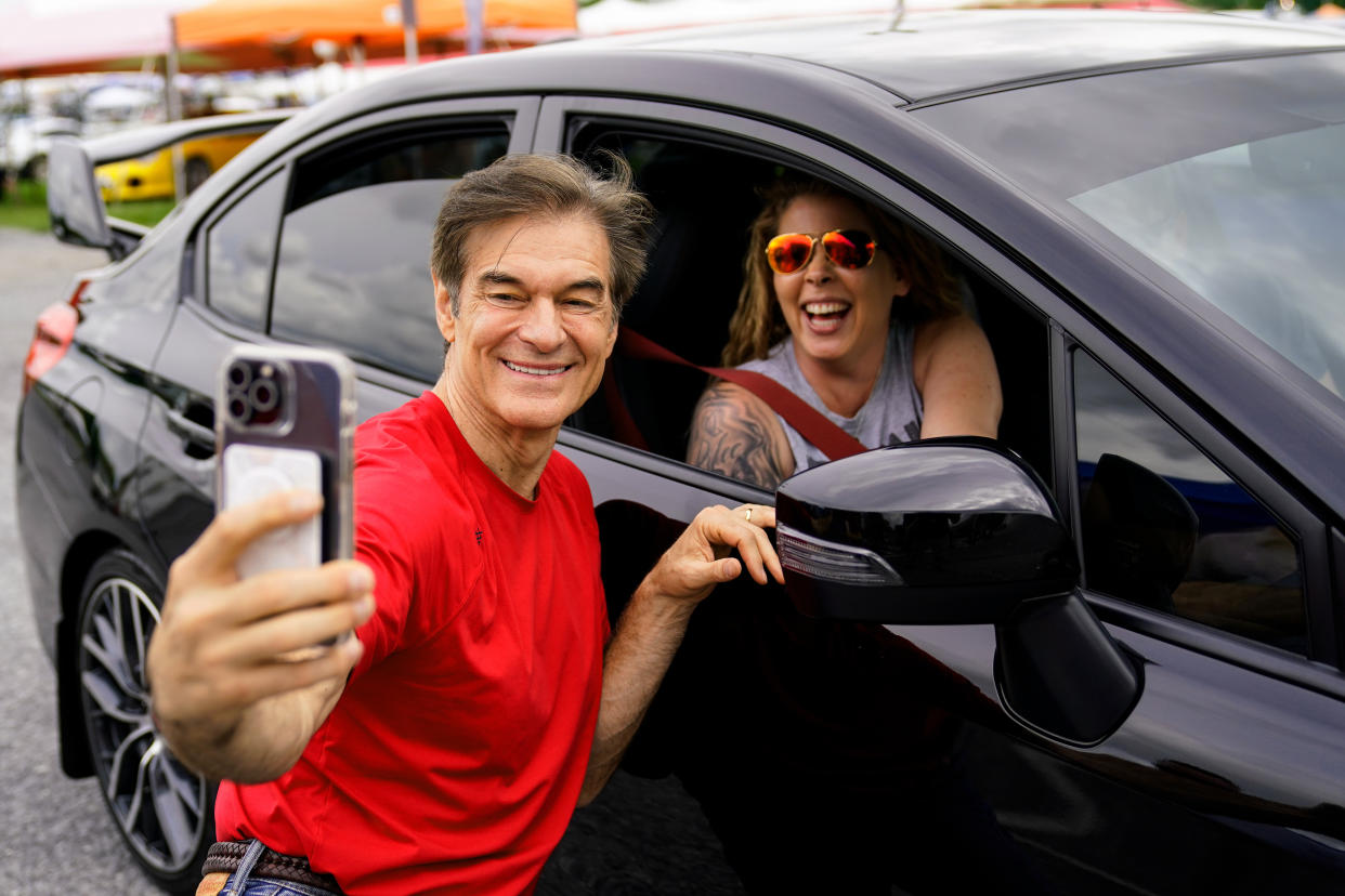 Mehmet Oz, a Republican candidate for U.S. Senate in Pennsylvania, takes a selfie with an attendee at a car show in Carlisle, Pa., on May 14.