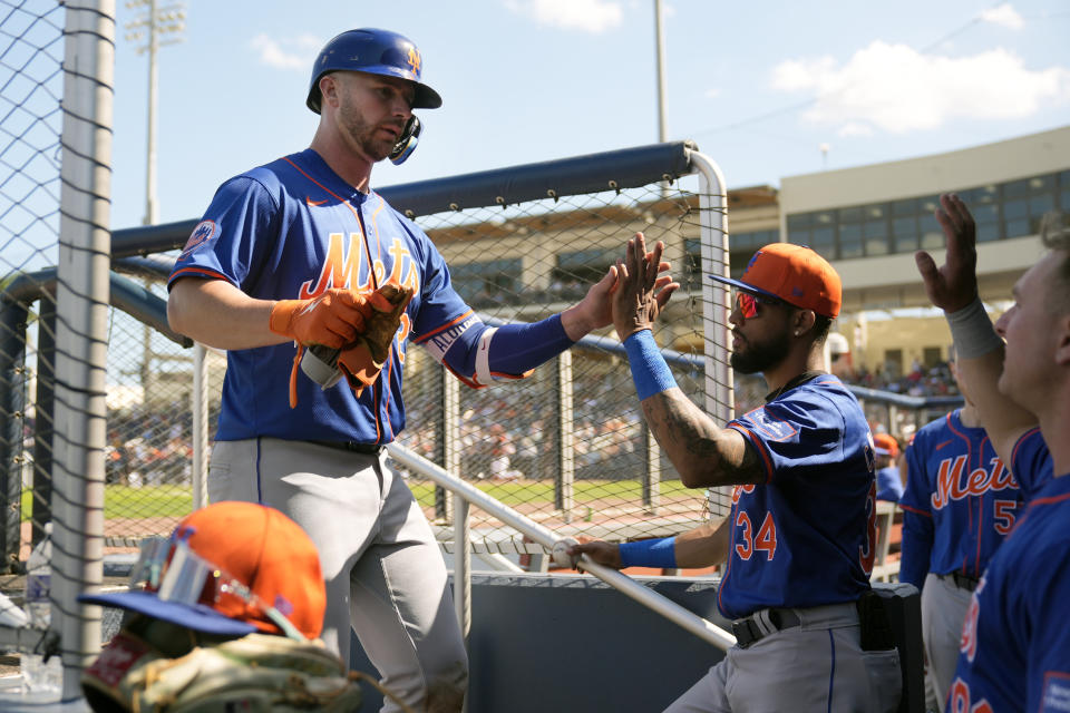 New York Mets' Pete Alonso is congratulated by teammates after hitting a ground-rule double during the fifth inning of a spring training baseball game Monday, Feb. 26, 2024, in West Palm Beach, Fla. (AP Photo/Jeff Roberson)