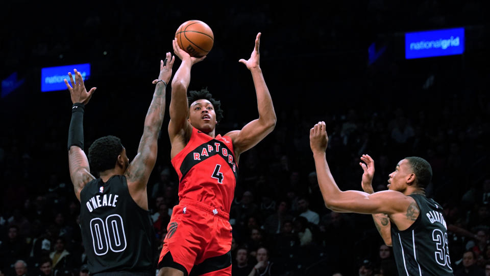 Toronto Raptors forward Scottie Barnes (4) shoots as Brooklyn Nets forward Royce O'Neale (00) and forward Nic Claxton (33) defend during the first half of an NBA basketball game Friday, Dec. 2, 2022, in New York. (AP Photo/Eduardo Munoz Alvarez)