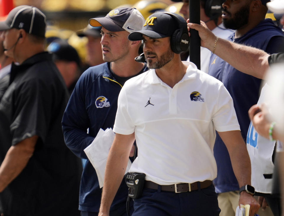 Michigan defensive coordinator Jesse Minter, center right, watches against East Carolina as analytics assistant Connor Stalions, center left, looks on during an NCAA college football game in Ann Arbor, Mich., Sept. 2, 2023. Stalions was suspended by the university last week and is at the center of a sign-stealing scheme that is being investigated by the NCAA. (AP Photo/Paul Sancya)