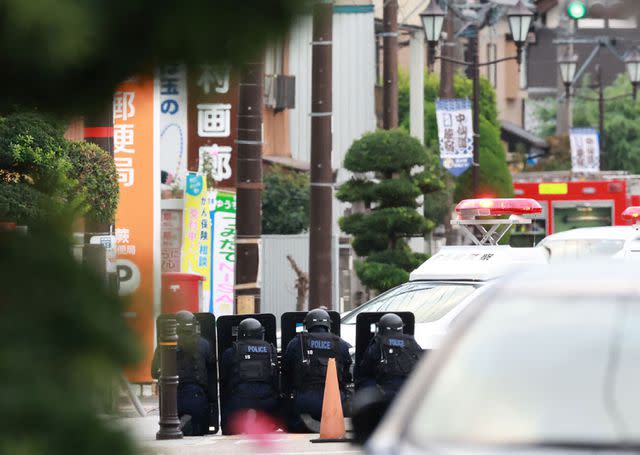 <p>STR/JIJI Press/AFP via Getty</p> Police officers guard the area around a post office in Japan