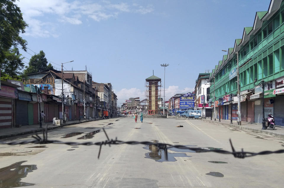 Kashmiri women walk at a deserted Lal Chowk square, a frequent site for anti-India protests, in Srinagar, Indian controlled Kashmir, Thursday, Aug. 8, 2019. The lives of millions in India's only Muslim-majority region have been upended since the latest, and most serious, crackdown followed a decision by New Delhi to revoke the special status of Jammu and Kashmir and downgrade the Himalayan region from statehood to a territory. Kashmir is claimed in full by both India and Pakistan, and rebels have been fighting Indian rule in the portion it administers for decades. (AP Photo/Sheikh Saaliq)