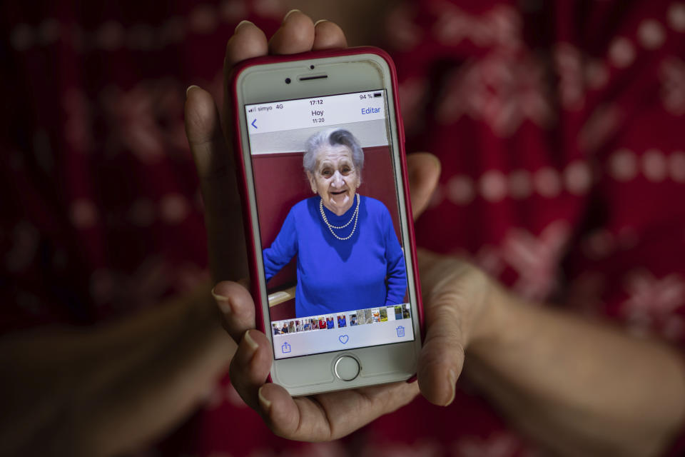 In this Monday, May 18, 2020 photo, Isabel Fraile shows a picture of her mother Estefania Carretero, 93, in Madrid, Spain. Estefania Carretero was one of the residents at the Usera Center for the Elderly, who died during the coronavirus outbreak in Spain. More than 19,000 coronavirus deaths in Spain's nursing homes have prompted a re-examination of a system. (AP Photo/Bernat Armangue)