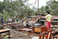 A man looks at his damaged house destroyed by strong winds brought about by Typhoon Bopha in Butuan City, Agusan del Norte, in the southern Philippine island of Mindanao. The death toll from a typhoon that ravaged the Philippines has jumped to 274 with hundreds more missing, as rescuers battled to reach areas cut off by floods and mudslides