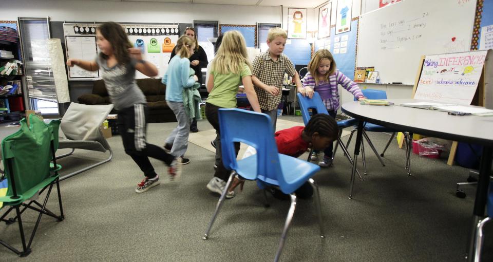 Student at Twin Lakes Elementary School in Federal Way, Wash., take shelter under a table as they take part in an earthquake drill, Thursday, Oct. 18, 2012. Millions of people took part in the “Great Shakeout” earthquake drill across the country and elsewhere Thursday to practice and prepare for the possibility of real quakes in the future. (AP Photo/Ted S. Warren)
