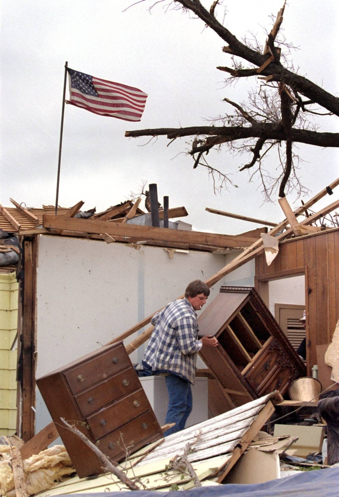 Jason Jones helps a friend move furniture out of a destroyed home in the Linwood neighborhood of Fort Worth on March 30, 2000, two days after a tornado.