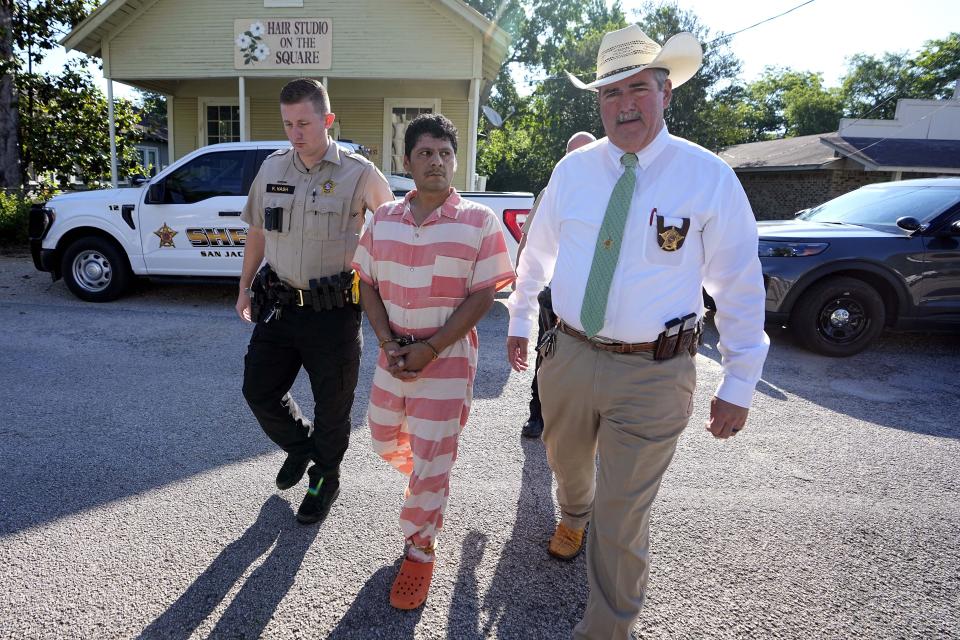 Francisco Oropeza, center, is escorted to the San Jacinto County courthouse by San Jacinto County Sheriff Greg Capers, right, for a hearing Thursday, May 18, 2023, in Coldspring, Texas. Oropeza is suspected of killing five people, including a 9-year-old boy, after neighbors asked him to stop firing off rounds in his yard. (AP Photo/David J. Phillip)