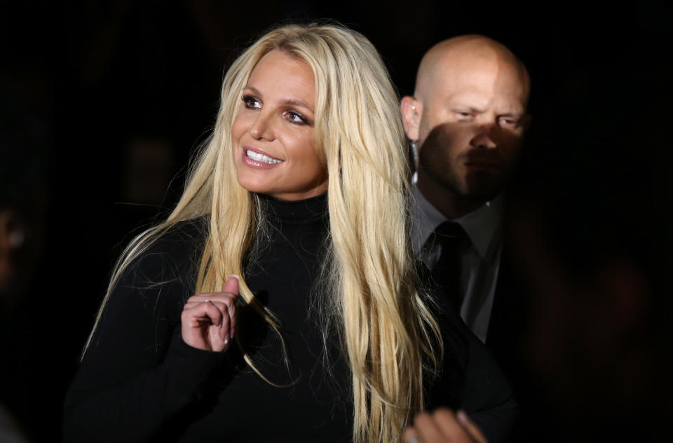 Britney smiles and waves at an event