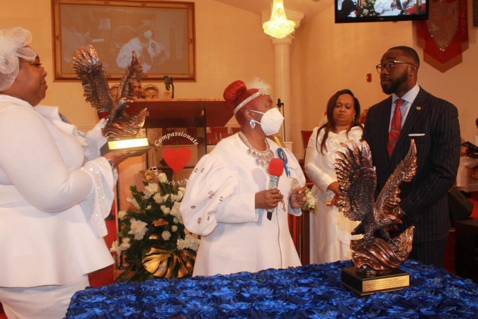 Senior Pastor Margaret Dennison of Compassionate Outreach Ministries, and her daughter, Shawndria Dennison, left, give a bronze statue of an eagle to Bernard Phillip, co-founder and president of Phillip & Sons The Funeral Directors Inc., of Melrose, for his service to the church.
(Photo: Photo by Voleer Thomas/For The Guardian)