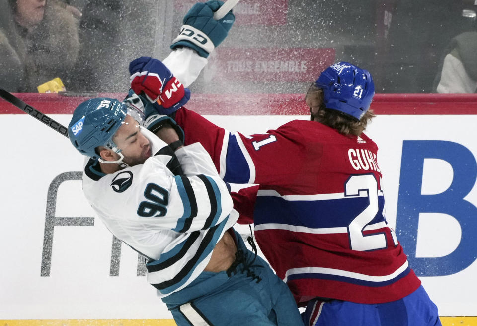 Montreal Canadiens' Kaiden Guhle (21) checks San Jose Sharks' Justin Bailey (90) during first-period NHL hockey game action in Montreal, Thursday, Jan. 11, 2024. (Christinne Muschi/The Canadian Press via AP)
