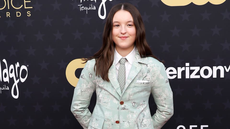 Nominated for her turn in “The Last of Us,” actress Bella Ramsey arrived in a mint-green Thom Browne suit with white blossom detailing and matching shoes. - Frazer Harrison/Getty Images
