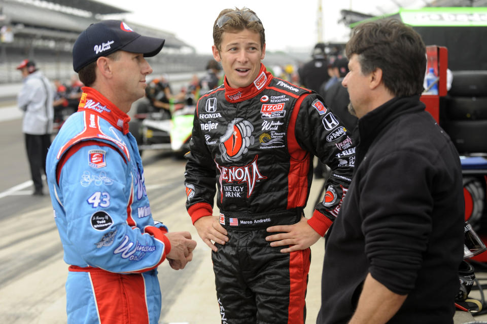 FILE - In this May 21, 2010, file photo, car owner Michael Andretti, right, talks with his son Marco Andretti, center, and cousin John Andretti during practice for the Indianapolis 500 auto race at the Indianapolis Motor Speedway in Indianapolis. John Andretti, a member of one of racing's most families, has died following a battle with colon cancer, Andretti Autosports announced Wednesday, Jan. 30, 2020. He was 56. (AP Photo/Tom Strickland, File)