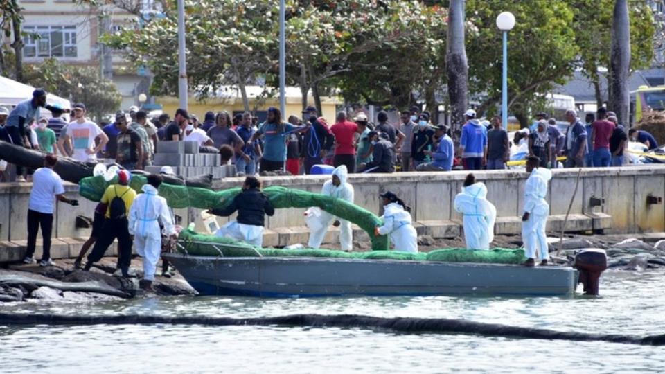 Voluntarios trabajan para contener el derrame en Mauricio