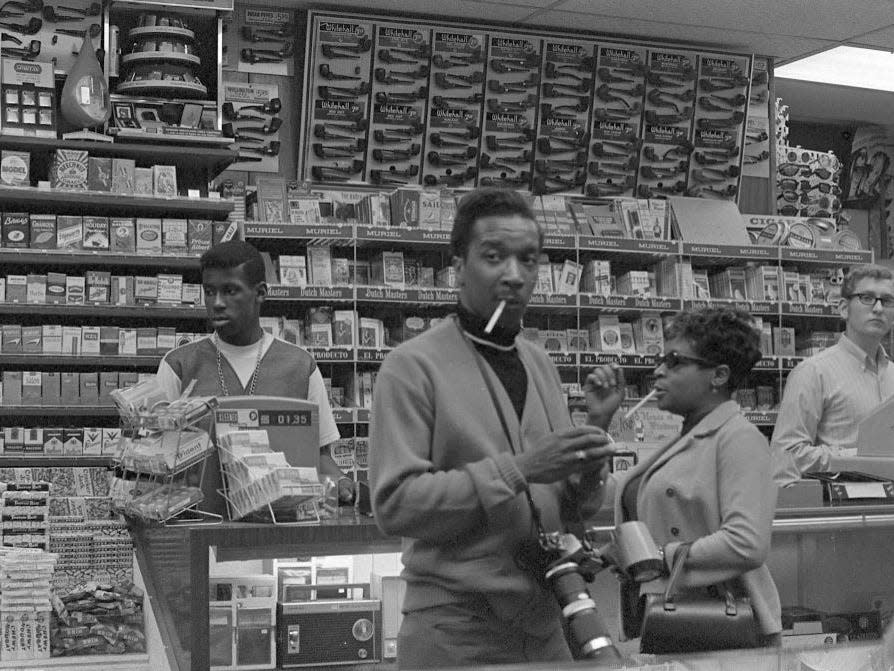 View of clerks and customers in an unidentified store that offers a wide range of cigarettes, as well as other tobacco-related products, candy, and portable radios at Coney Island, Brooklyn, New York, New York, July 4, 1968.