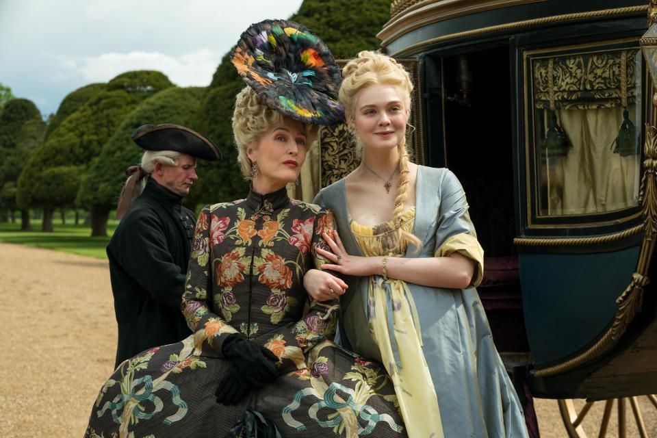 Gillian Anderson and Elle Fanning stand outside a carriage