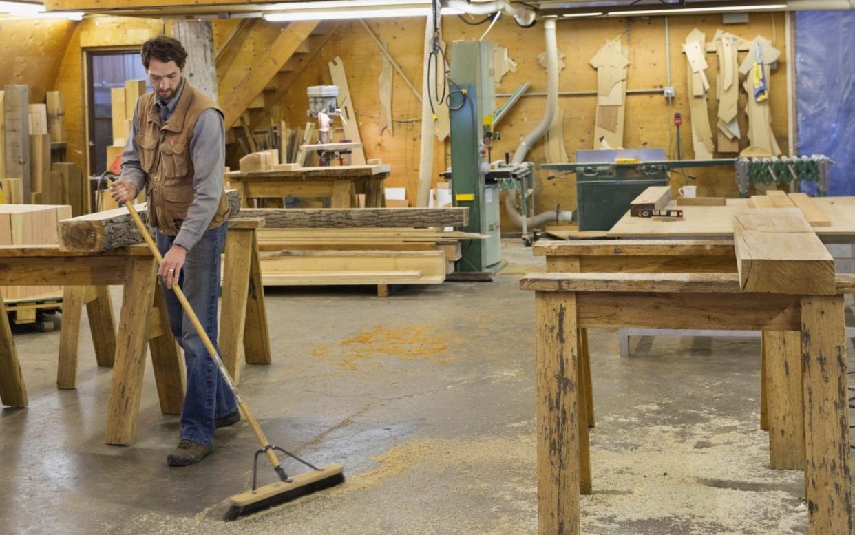 Furniture maker told to stop sweeping up wood dust from his factory floor with a broom by concerned health and safety bosses - Hero Images