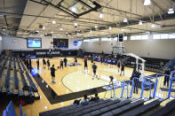 Yeshiva and Worcester Polytechnic Institute players warm up before an NCAA DIII college basketball game that allowed no spectators on Friday, March 6, 2020, in Baltimore, Md. The game at Johns Hopkins University is believed to be the first U.S. sports event held without fans because of the new coronavirus. (AP Photo/Terrance Williams)