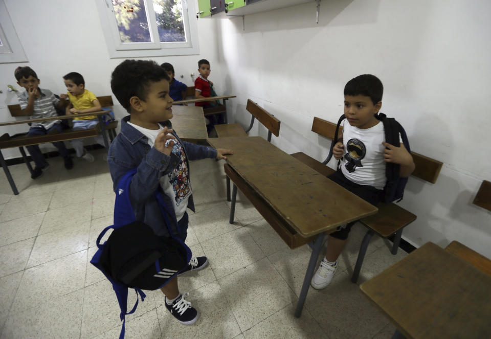 Schoolchildren arrive in their classroom in a private school of Birkhadem, outside Algiers, Wednesday, Sept.21, 2022. Algerian children went back to school Wednesday Sept. 21, 2022 for the first time since the president last month ordered schools to switch from teaching French as a second language alongside Arabic to English instead. The government says the move is a modernization effort but it is also seen as a way for Algeria to distance itself from its past as a French colony. (AP Photo/Fateh Guidoum)