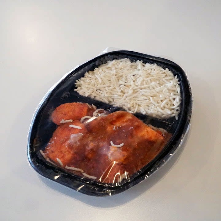 A frozen tray of chicken tikka masala with rice