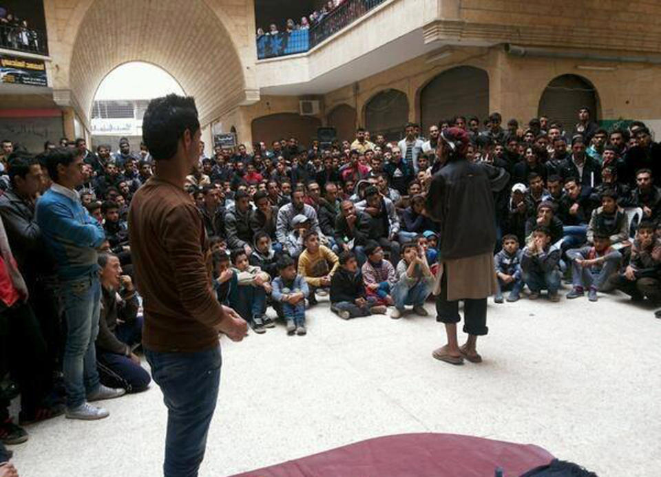 FILE - In this file picture released Thursday, Nov. 28, 2013, and posted on the Facebook page of a militant group, a member of the al-Qaida linked Islamic State of Iraq and the Levant (ISIL) gives a lecture at the Engineering College in the northern city of Raqqa, Syria. Once a vibrant, mixed city considered a bastion of support for President Bashar Assad, the eastern city of Raqqa is now a shell of its former life, transformed by al-Qaida militants into the nucleus of the terror group's version of an Islamic caliphate they hope one day to establish in Syria and Iraq. In rare interviews with The Associated Press, residents and activists in Raqqa describe a city where fear prevails, music has been banned, Christians have to pay religious tax in return for protection and face-veiled women and pistol-wielding men in jihadi uniforms patrol the streets. (AP Photo, File)