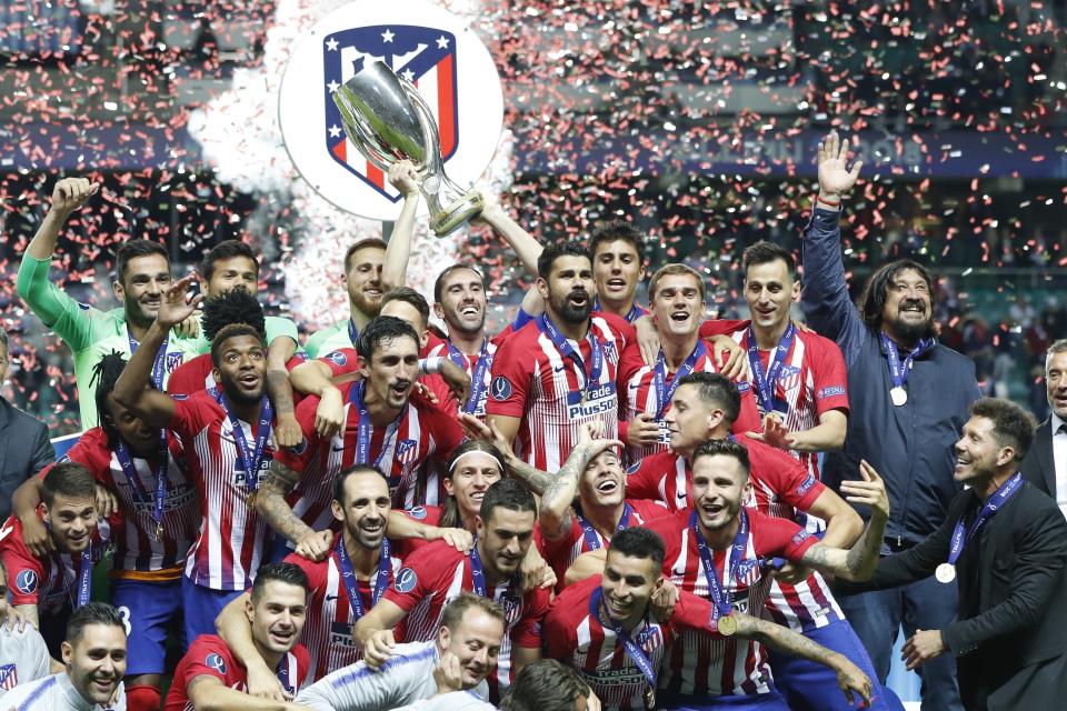 Atletico's team members celebrate with trophy after the UEFA Super Cup final soccer match between Real Madrid and Atletico Madrid at the Lillekula Stadium in Tallinn, Estonia, Wednesday, Aug. 15, 2018. (AP Photo/Pavel Golovkin)