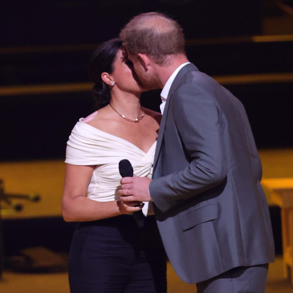  Prince Harry and Meghan Markle kiss onstage 