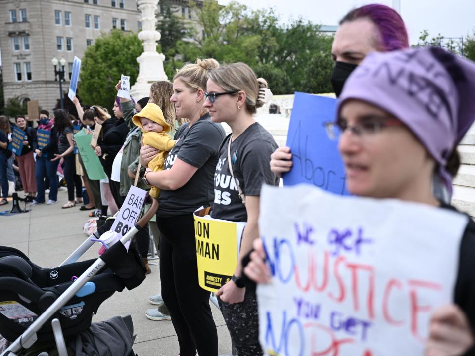 Sarah Goggans (C) holds her daughter Lilith Centola in front of the US Supreme Court as demonstrators gather in Washington, DC, on May 3, 2022.