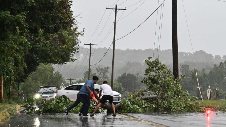 PHOTO: Motorists stop to remove a fallen tree from the roadway following a severe thunderstorm on August 7, 2023 in Myersville, Md. (Ricky Carioti/The Washington Post via Getty Images)