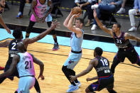 Miami Heat guard Goran Dragic, center, is defended by Philadelphia 76ers center Joel Embiid, left, guard Shake Milton (18) and guard George Hill (33) during the first half of an NBA basketball game Thursday, May 13, 2021, in Miami. (AP Photo/Lynne Sladky)