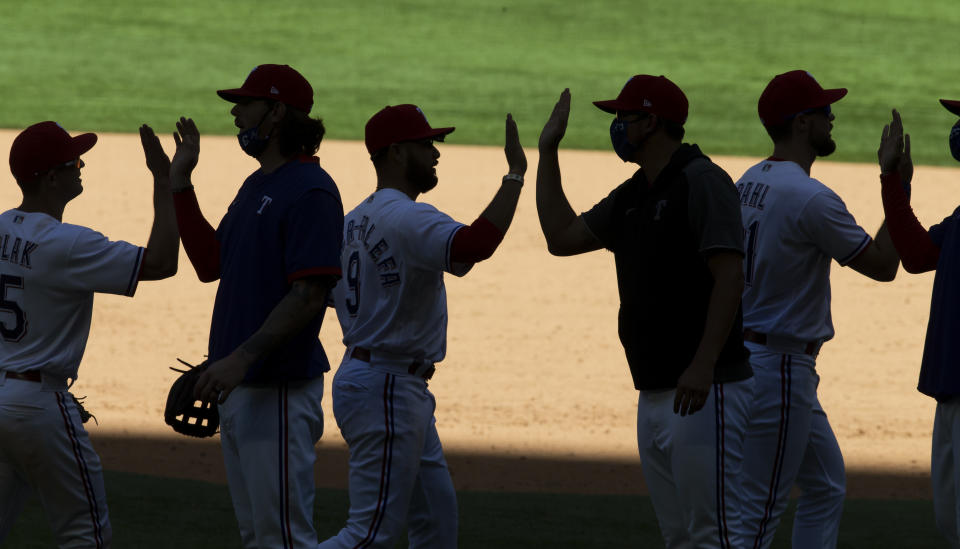 The Texas Rangers celebrate a 2-1 win over the Toronto Blue Jays after a baseball game, Wednesday, April 7, 2021, in Arlington, Texas. (AP Photo/Brandon Wade)