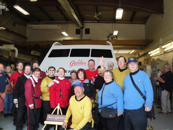"Star Trek" fans, including members of the U.S.S. Justice and U.S.S. Challenger fan groups, pose with the fully restored Galileo shuttlecraft from the original "Star Trek" TV series during an unveiling on June 22, 2013, at Master Shipwrights In