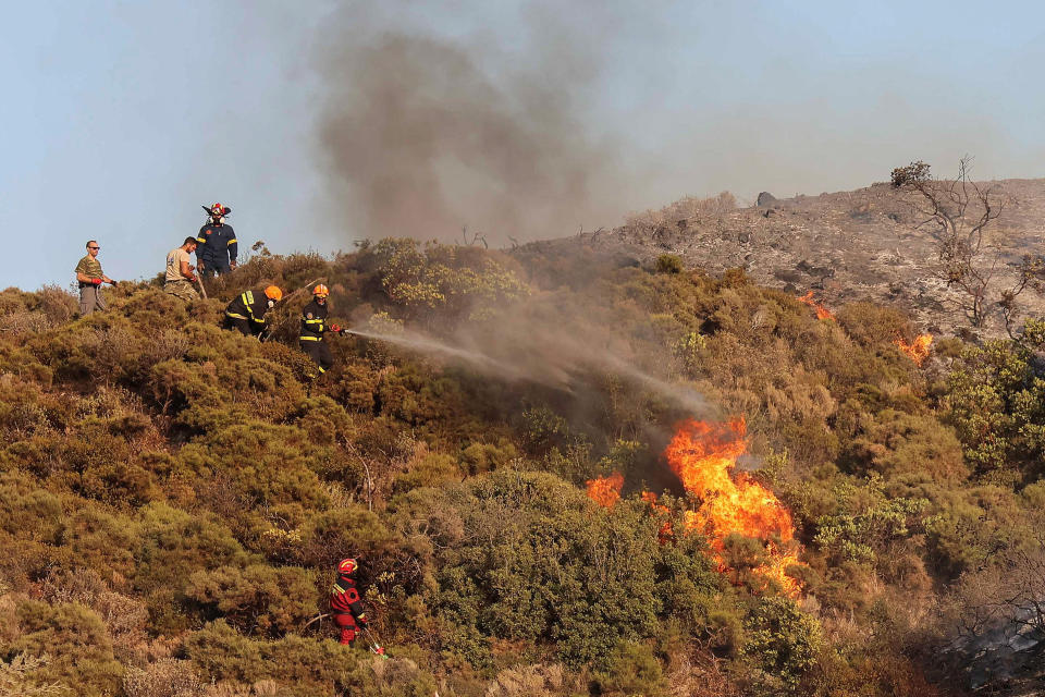 Firefighters and volunteers try to extinguish a wildfire burning in the village of Vati, on the island of Rhodes, Greece, July 26, 2023. REUTERS/Nicolas Economou