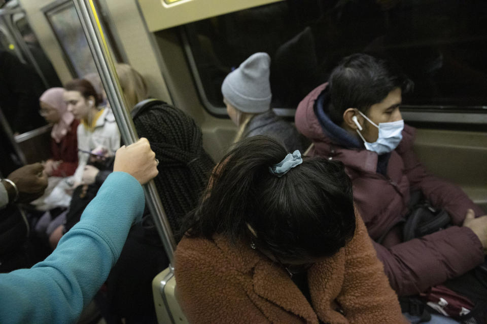 A commuter holds on to a vertical pole while another wears a mask as they ride the subway, Wednesday, March 4, 2020, in New York. "It may be possible that a person can get COVID-19 by touching a surface or object that has the virus on it and then touching their own mouth, nose, or possibly their eyes, but this is not thought to be the main way the virus spreads," according to the Centers for Disease Control and Prevention, (CDC). (AP Photo/Mark Lennihan)
