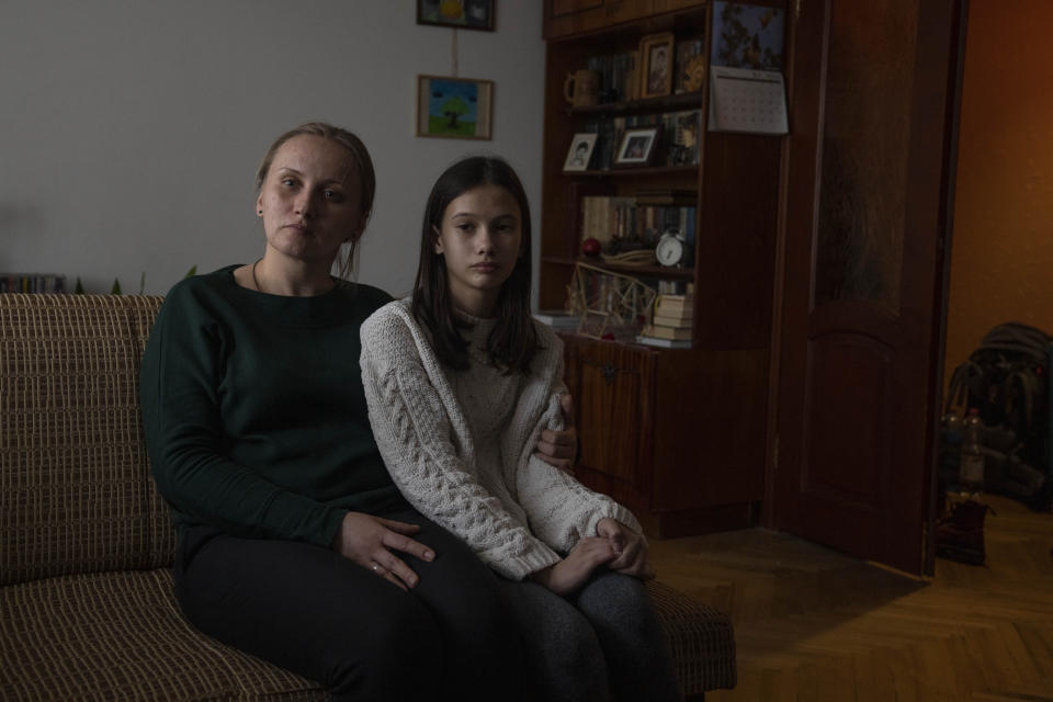 Olha Salivonchuk, head of the local association of apartment owners, sits with her 13-year-old daughter Solomiya, in their apartment, in Lviv, western Ukraine, Sunday, April 3, 2022. Olha has never considered leaving, even when a Russian airstrike in Lviv made their building shake. (AP Photo/Nariman El-Mofty)