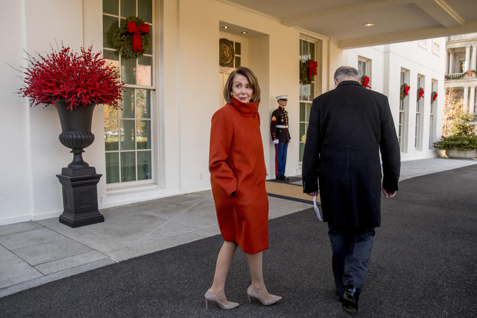 House Minority Leader Nancy Pelosi of Calif., left, speaks to a reporter as she and Senate Minority Leader Sen. Chuck Schumer of N.Y., right, walk back into the West Wing after speaking to members of the media outside of the White House in Washington, Tuesday, Dec. 11, 2018, following a meeting with President Donald Trump. (AP Photo/Andrew Harnik)