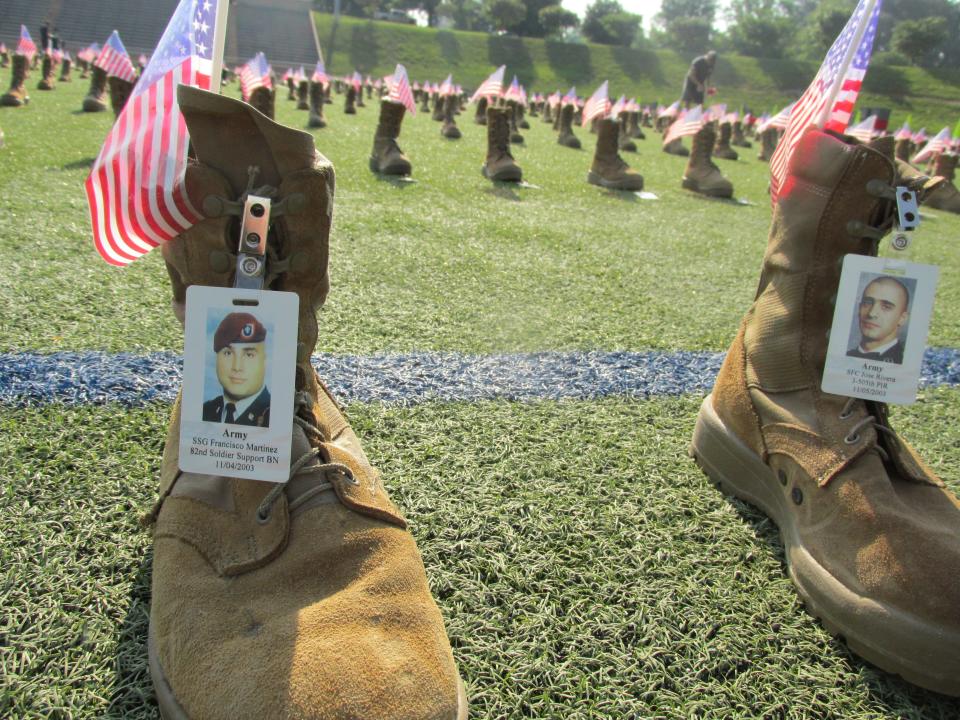 Volunteers place more than 7,500 boots out Friday, May 20, 2022, at Hedrick Stadium on Fort Bragg to represent service members who have died since 9/11.