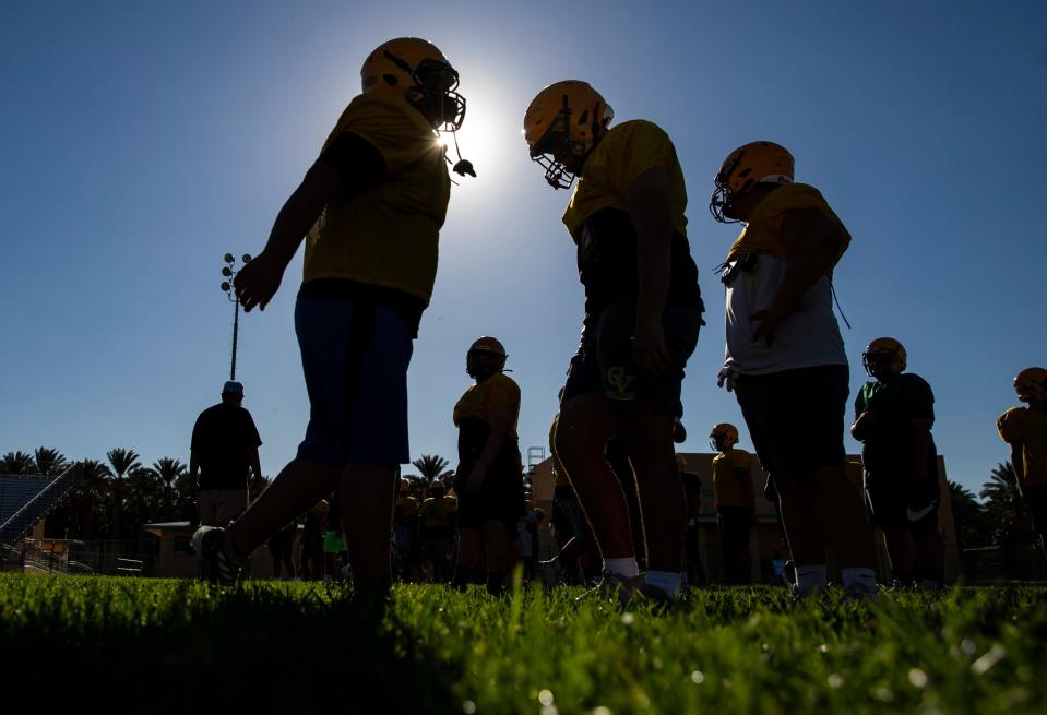 Coachella Valley players run through warmups at the start of football practice at Coachella Valley High School in Thermal, Calif., Friday, Aug. 4, 2023. 