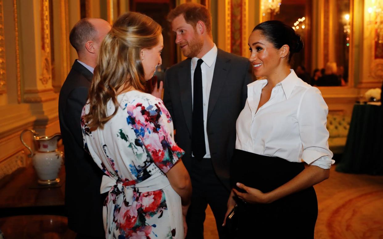 The Duchess of Sussex clutches her baby bump as she and the Duke attend the Endeavour Fund Awards - Getty Images Europe