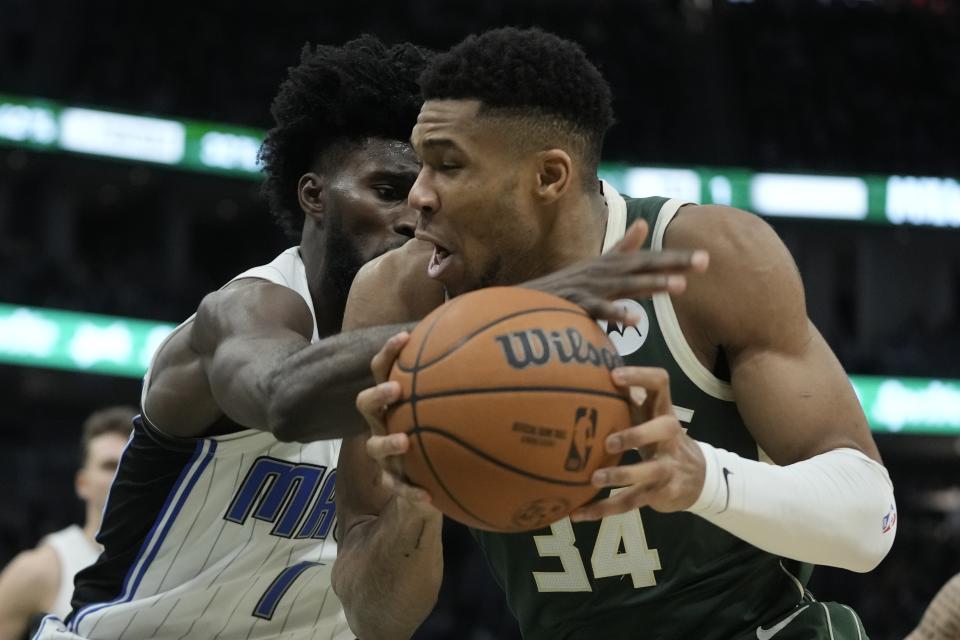 Orlando Magic's Jonathan Isaac fouls Milwaukee Bucks' Giannis Antetokounmpo during the second half of an NBA basketball game Thursday, Dec. 21, 2023, in Milwaukee. The Bucks won 118-114. (AP Photo/Morry Gash)