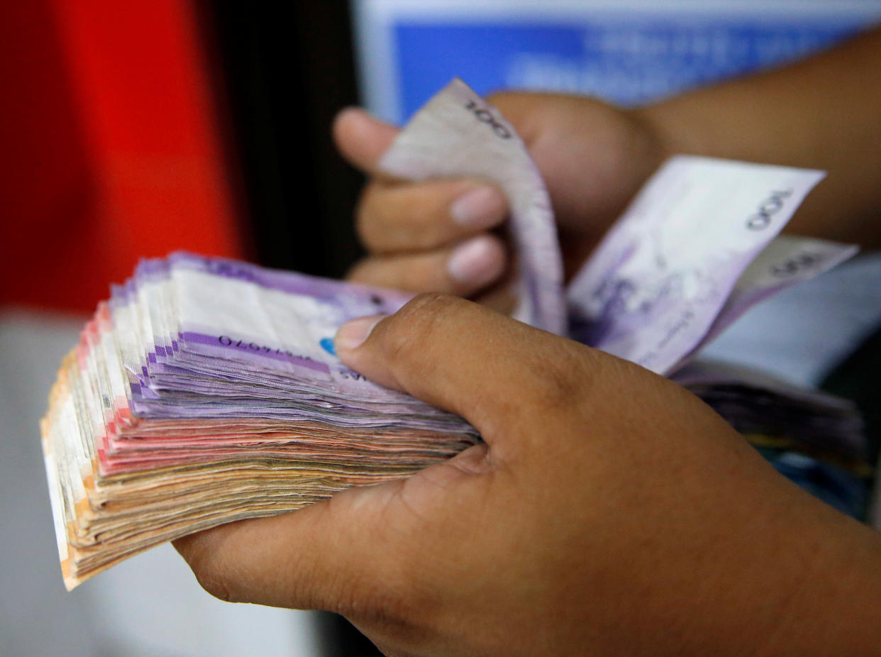 A man counts a wad of Philippine Peso bills he received from a relative working abroad at a money remittance center in Makati City, Metro Manila, Philippines September 19, 2018. REUTERS/Eloisa Lopez