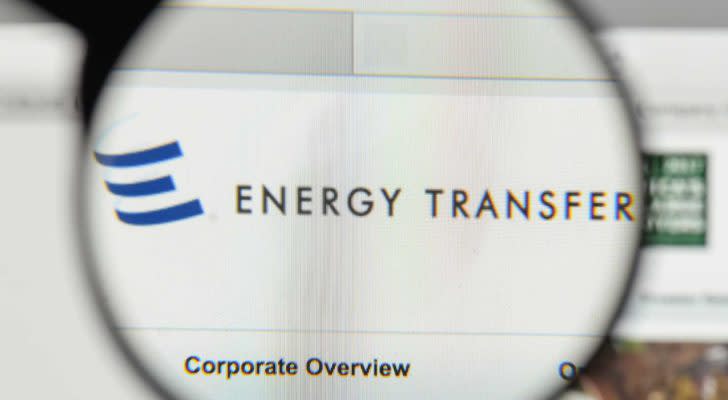 A magnifying glass zooms in on the Energy Transfer (ET) website.
