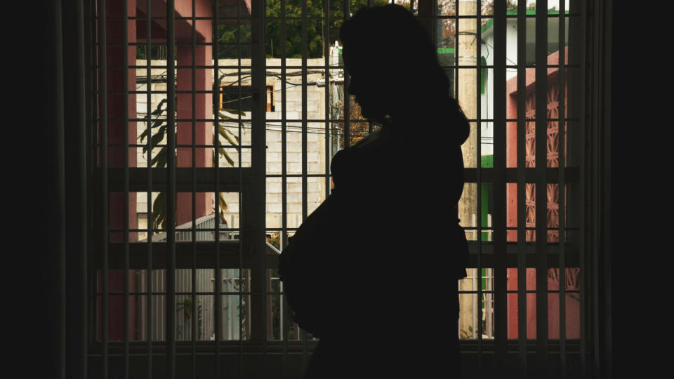 Silhouette Woman Standing Against Window In Building