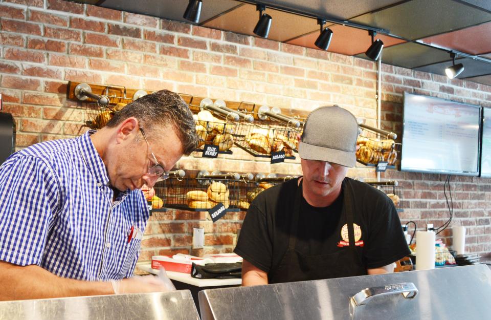 Ed Schwartzman, left, and Ritchie Bowling work together at Gables Bagels to fill a customer's order on Monday, Aug. 8, 2022.