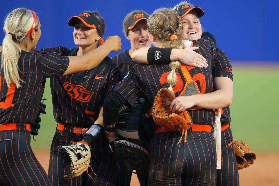 Oklahoma Sate's Kelly Maxwell, facing camera, hugs Julia Cottrill (25) after winning a Women's College World Series softball game between the Oklahoma State University Cowgirls (OSU) and the Florida Gators at USA Softball Hall of Fame Stadium in Oklahoma City, Saturday, June 4, 2022. Oklahoma State won 2-0.