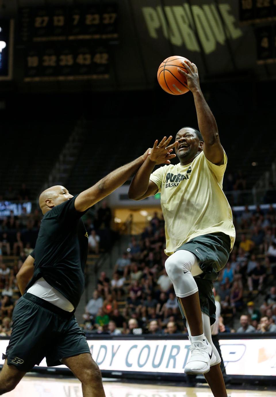 Roy Hairston of the Gold team with a shot over Brandon Brantley of the Black in the Purdue Alumni basketball game Saturday, August 4, 2018, at Mackey Arena. The Black team defeated the Gold 101-91.